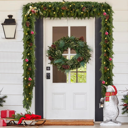 Decorative Christmas garland with lights and ornaments on a door, featuring a wreath and penguin statue.