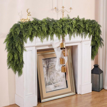 Decorative greenery on a fireplace mantel with gold accents