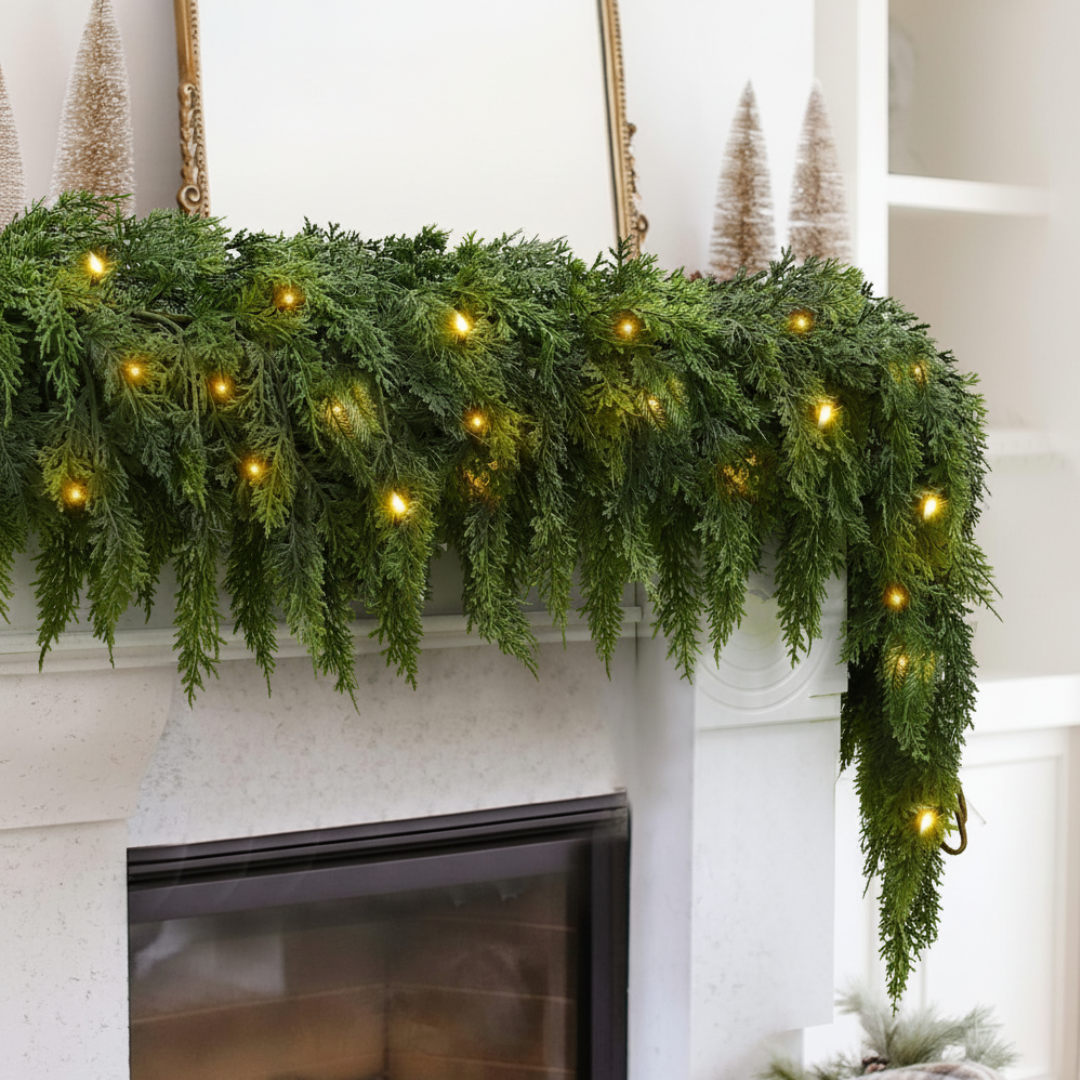 Green garland with lights on a fireplace mantel