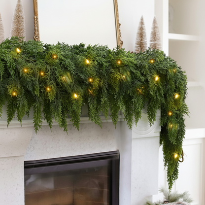 Green garland with lights on a fireplace mantel